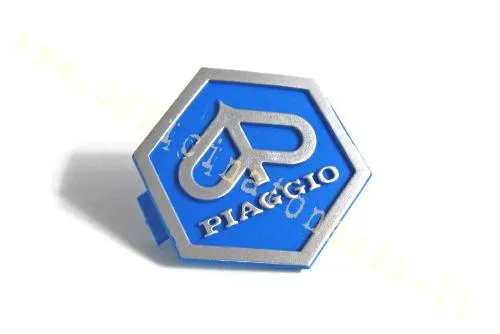 Scudetto esagonale Olympia 32x37 mm a incastro per mascherina Vespa PX Arcobaleno, PK XL e T5. Verificare la sede sulle varianti Cosa.